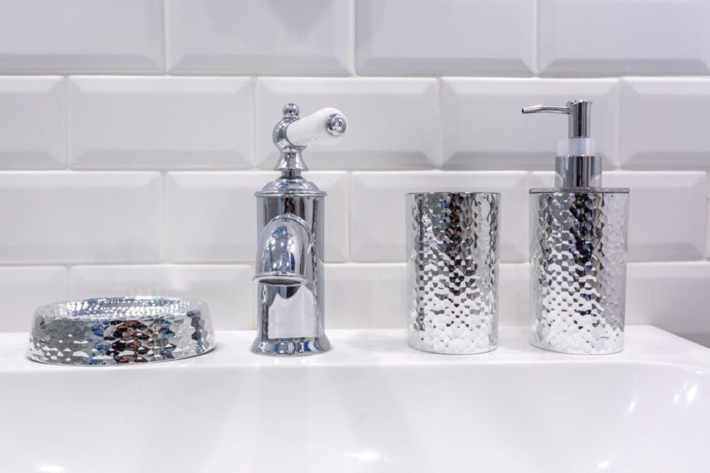 Soap and shampoo dispensers near Ceramic Water tap sink with faucet in expensive loft bathroom